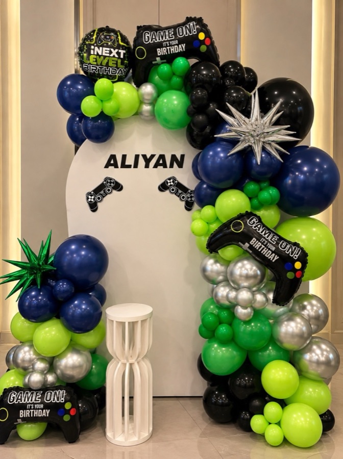 Game-themed birthday balloon arch in navy, green, silver and black